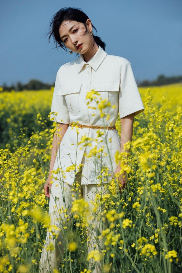 万茜一身白色套装清新优雅，油菜花田里曼妙生姿，尽显春日美好